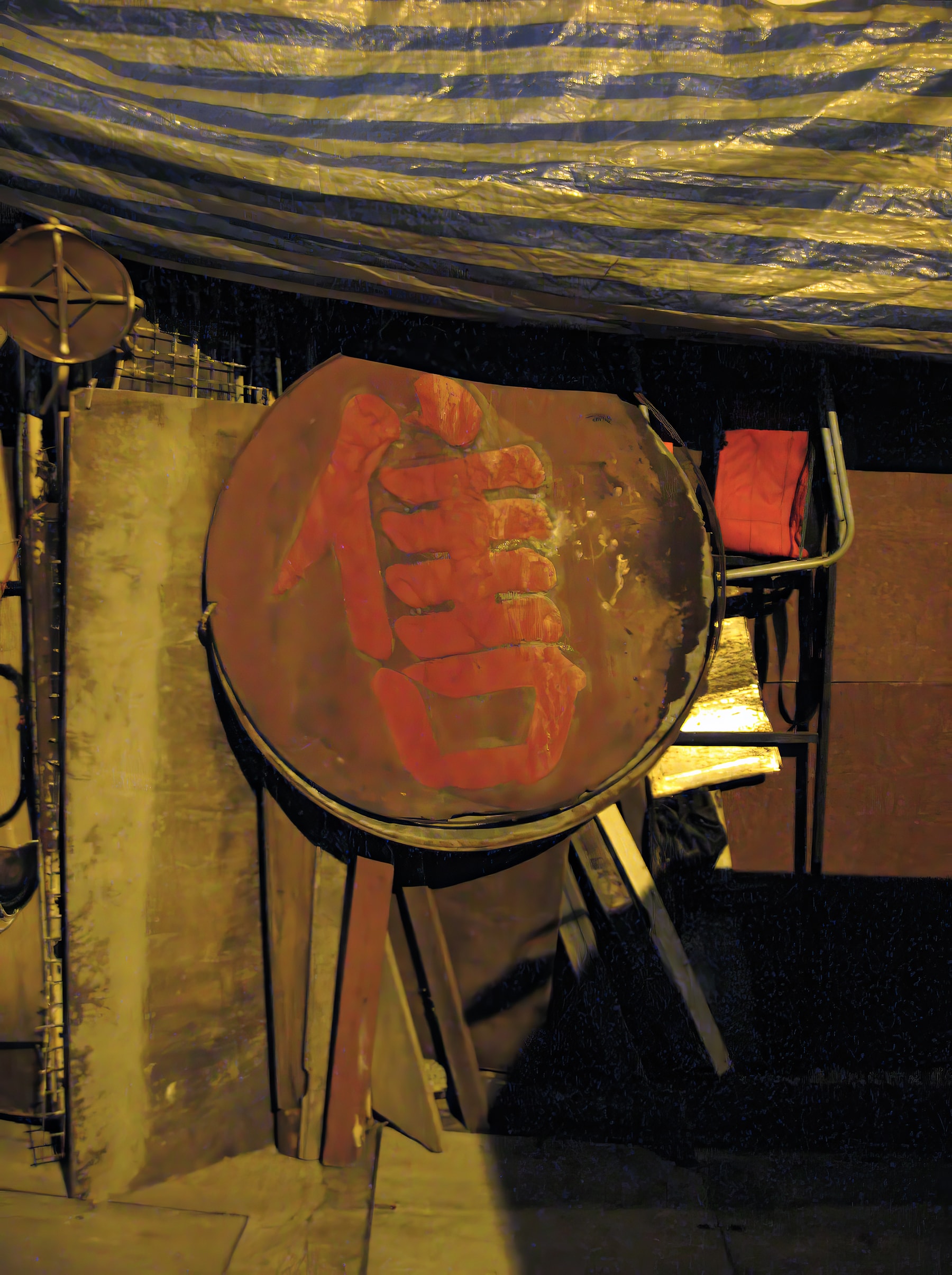 Large red Chinese character on circular sign under tarp, Hong Kong
